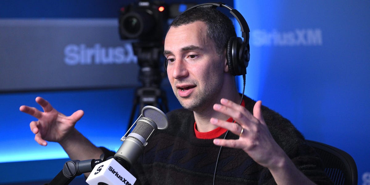 Photo of Jack Antonoff looking thoughtful, with a microphone in front of him.