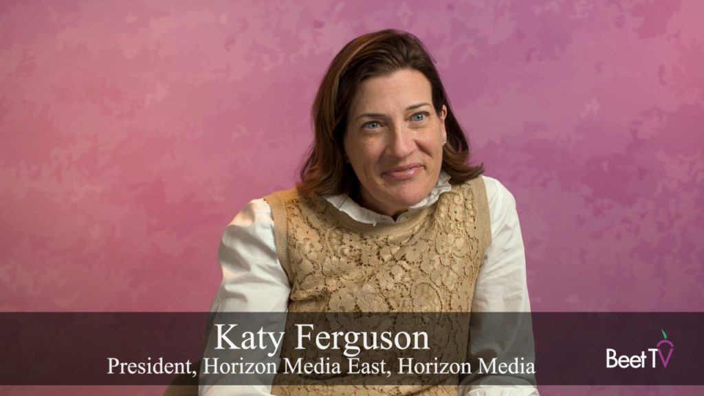 Katy Ferguson speaking at a panel, with AI-themed graphics in the background.