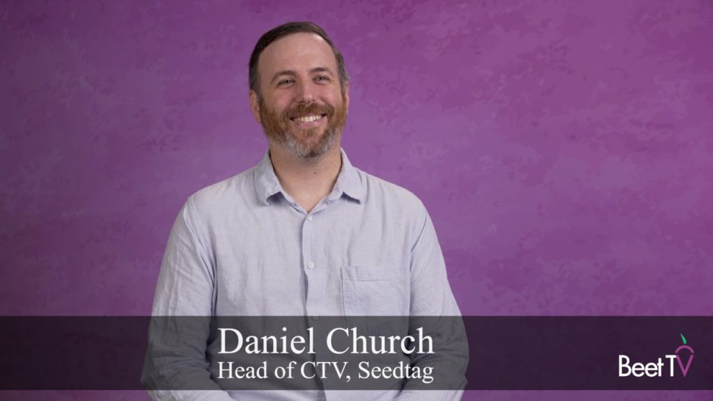 A person watching TV, with an ad appearing on screen.