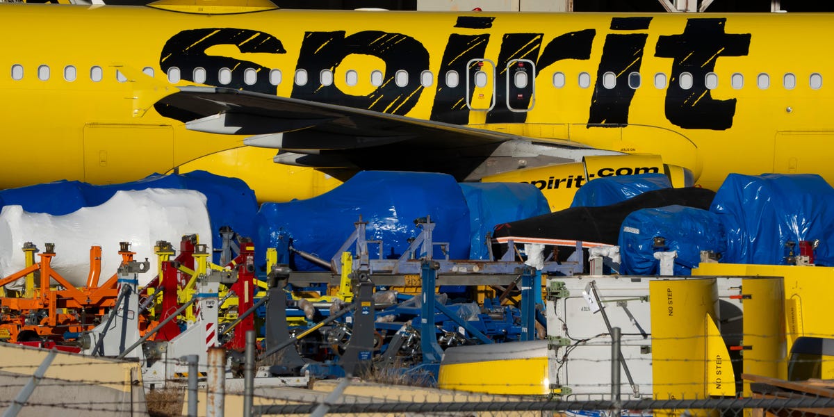 An excavator tearing apart a Spirit Airlines Airbus A320neo jet.