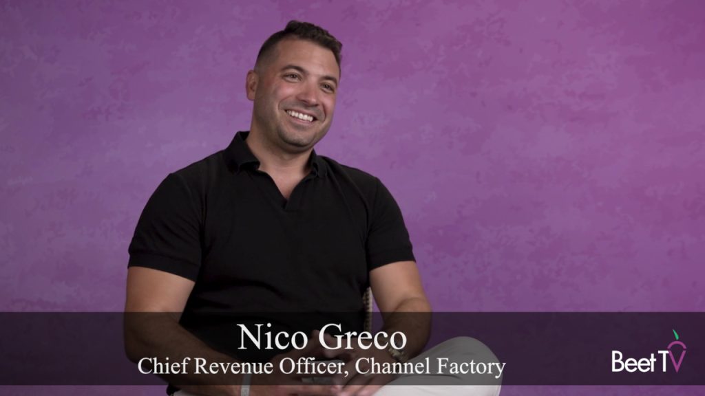 Nico Greco of Channel Factory speaking at a conference, with a digital graphic representing AI content in the background.