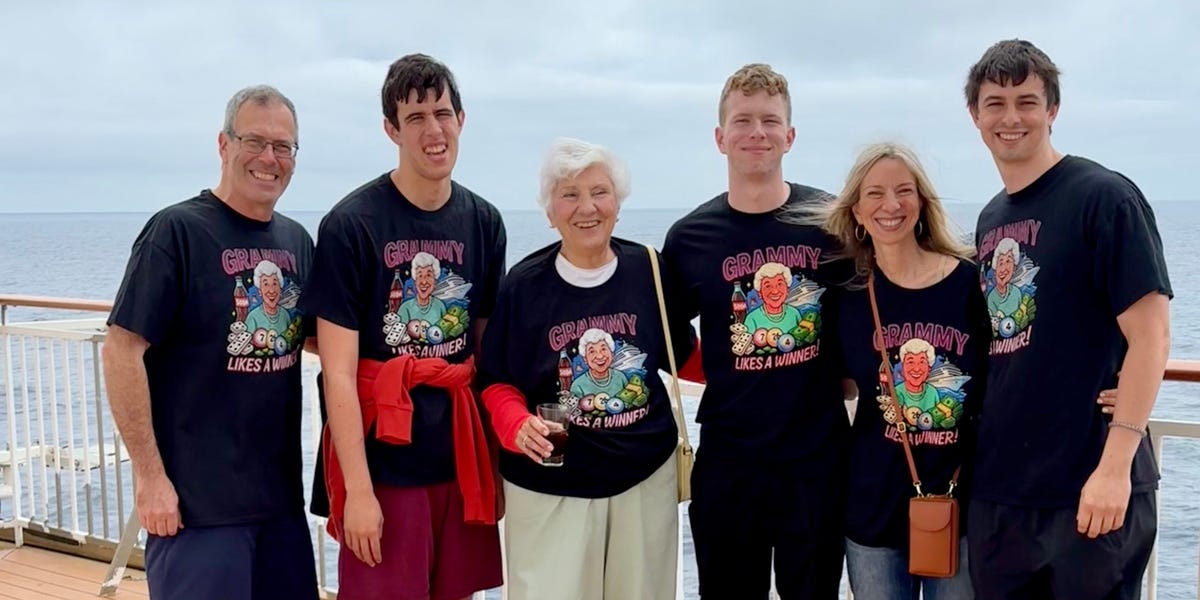 A family laughing together on the deck of a cruise ship.